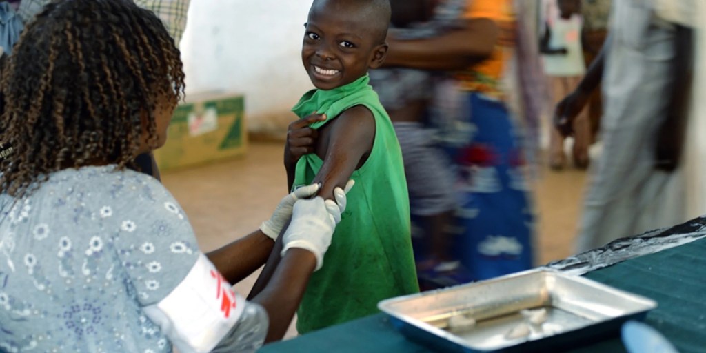 Young girl getting vaccination from a health care professional